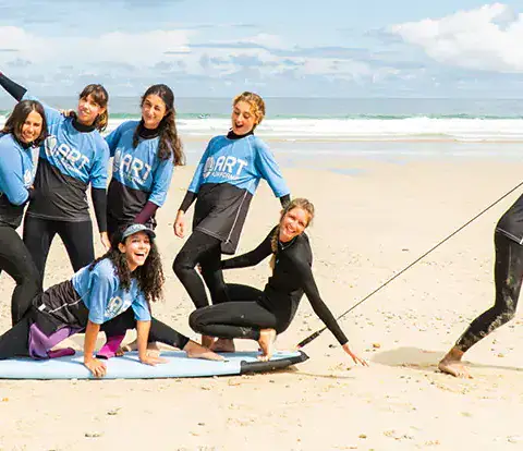 Groupe de cours de surf sur la plage avec le moniteur