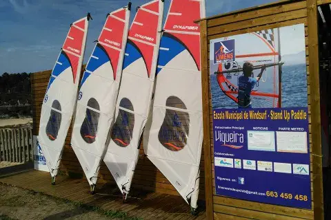 Voiles de windsurf de l'école devant le panneau d'information