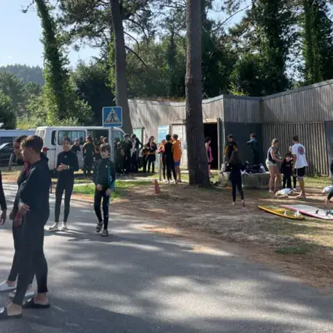 Groupe d'élèves en combinaison sur le chemin de la plage