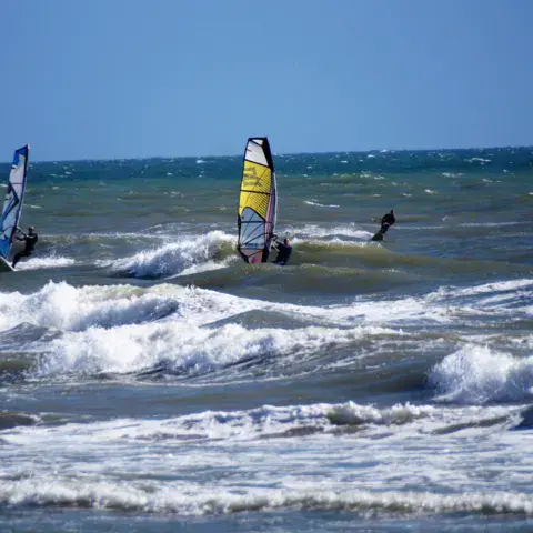 Windsurfeurs et kite dans les vagues
