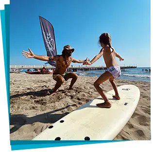 Moniteur et élève lors d'un exercice sur la planche, sur le sable