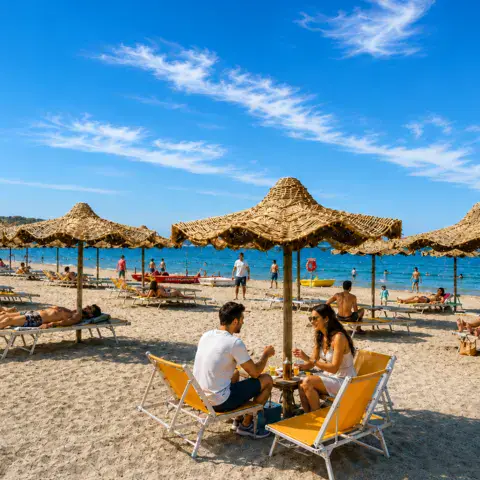 Plage avec parasols de paille et transats