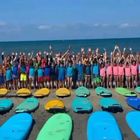 Planches alignées sur la plage avec les participants du camp