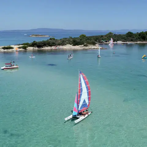 Voile sur une baie aux eaux turquoise