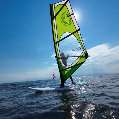 Windsurfeur sous une voile jaune