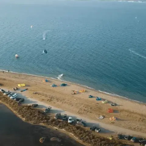 Vue aérienne d'un spot de kitesurf avec plusieurs voiles