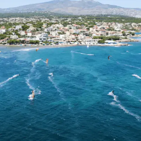 Kitesurfeurs au large d'un village côtier, vue aérienne