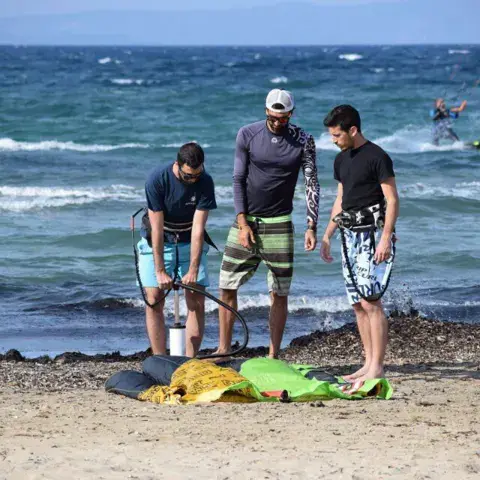 Préparation du matériel de kitesurf avant un cours sur la plage