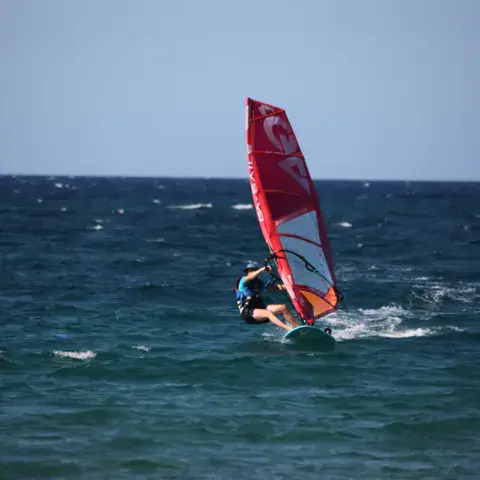 Windsurfeur sous voile rouge