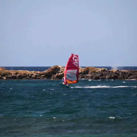 Windsurfeur près d'un rocher