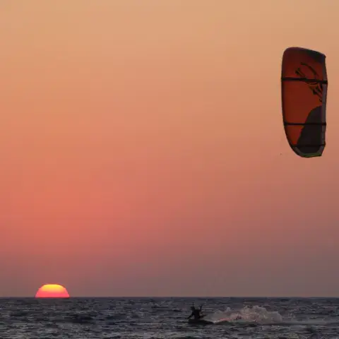 Plage de galets et kite en vol
