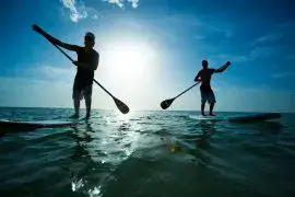 Deux pratiquants de stand up paddle à contre-jour