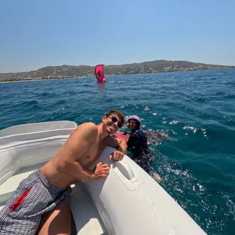 Bateau d'assistance en mer, kite rose au loin