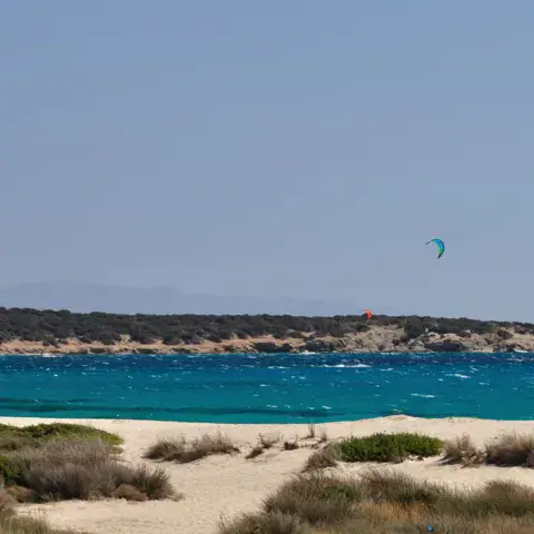 Plage et côte avec deux kites au loin