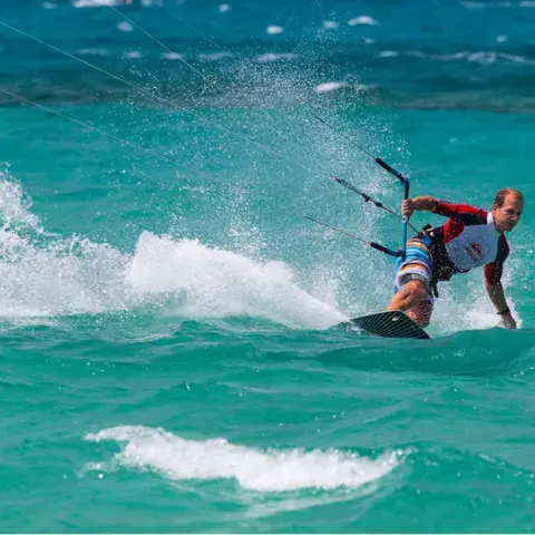 Kitesurfeur en navigation sur une eau turquoise