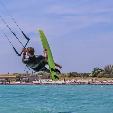 Kitesurfeur en saut devant la plage