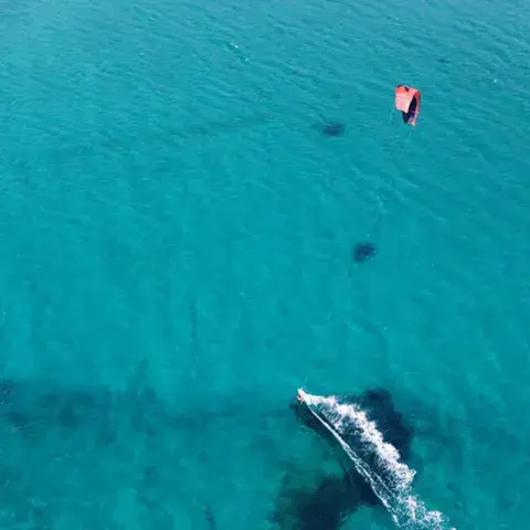 Kitesurfeur sur une eau turquoise vue du ciel