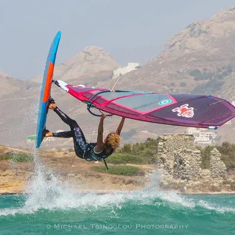 Windsurfeur en saut près de la côte rocheuse