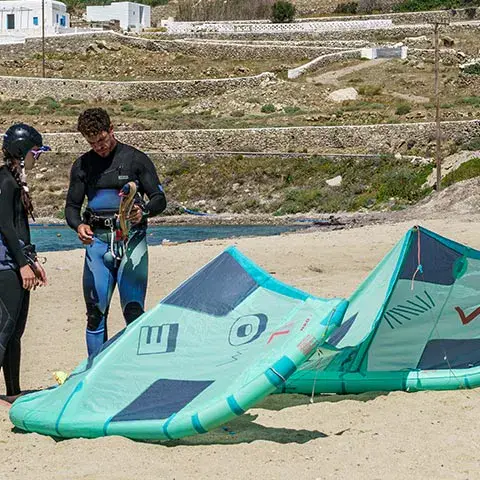 Cours de kitesurf sur la plage, deux personnes devant une aile