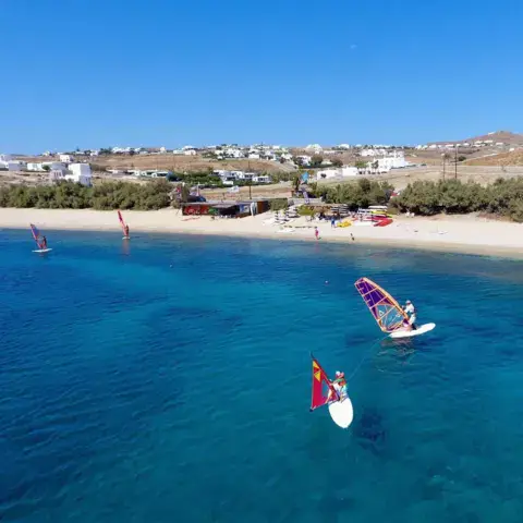 Vue de la plage et de la baie, windsurfeurs et SUP sur l'eau