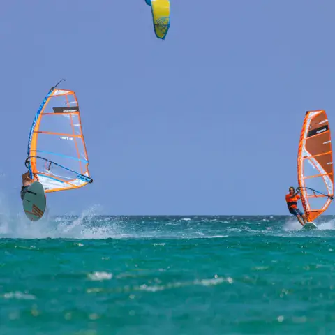 Deux windsurfeurs au-dessus de l'eau turquoise