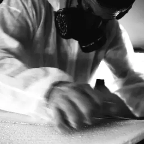 Ponçage d'une planche de surf à l'atelier