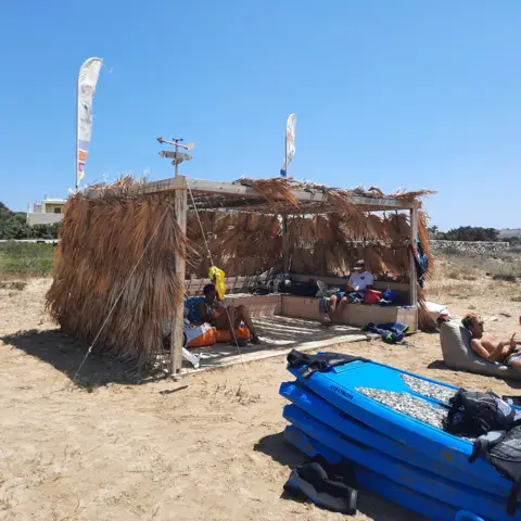 Abri en roseaux et matériel nautique sur la plage de sable
