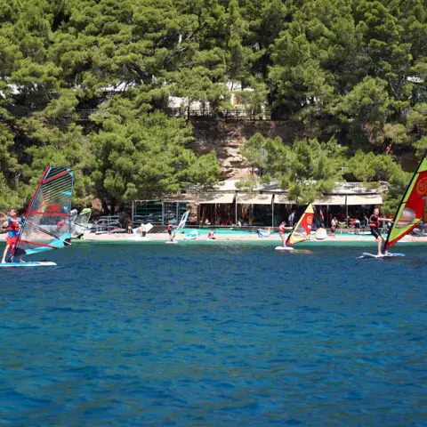 Planches à voile devant la plage et la pinède