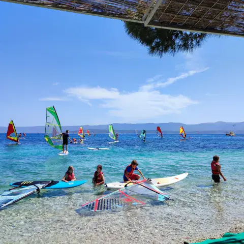 Planches à voile et matériel d'école dans l'eau peu profonde
