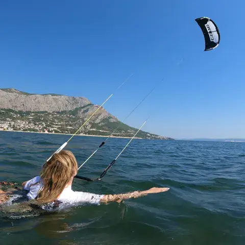 Élève de kitesurf dans l'eau peu profonde, kite dans le ciel