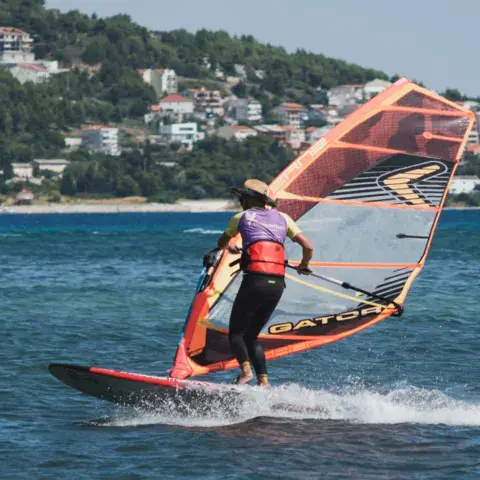 Windsurfeur en navigation devant la côte