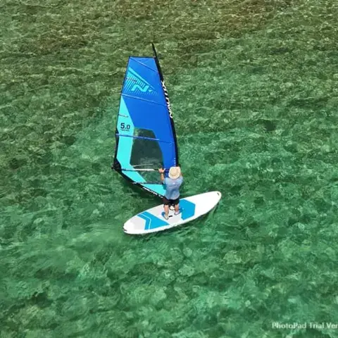 Élève en windsurf dans une eau claire