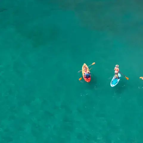 Trois kayaks sur une eau turquoise vus du ciel