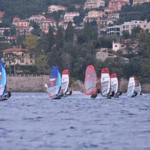 Flotte de planches à voile devant les maisons de la côte