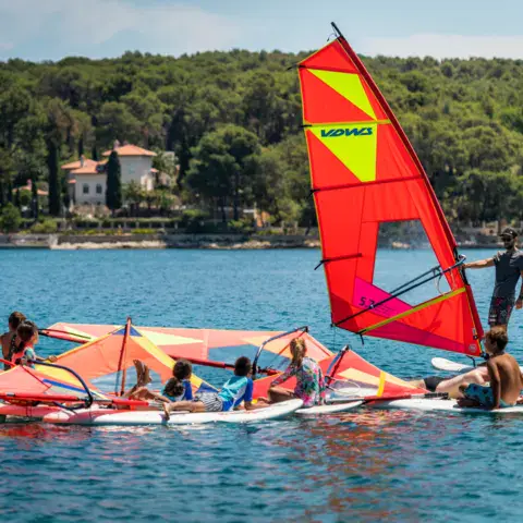 Groupe d'élèves et planches à voile sur l'eau