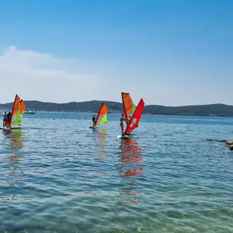 Windsurfeurs sur l'eau avec des voiles colorées