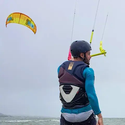 Pratiquant dans l'eau, kite au-dessus de lui