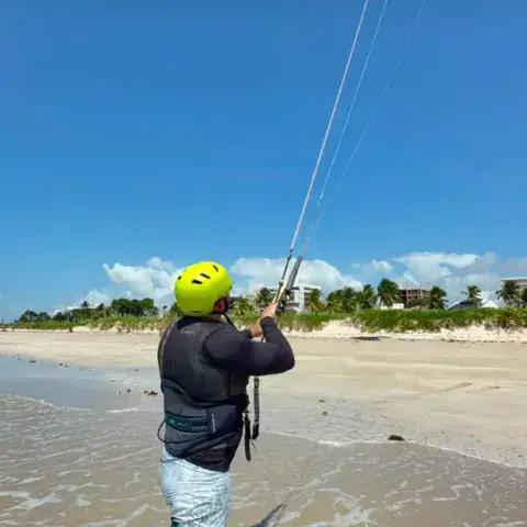 Élève contrôlant un kite sur la plage
