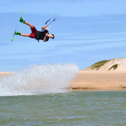 Saut en kitesurf devant les dunes