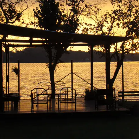 Ponton et abri en bois au bord du plan d'eau au coucher du soleil