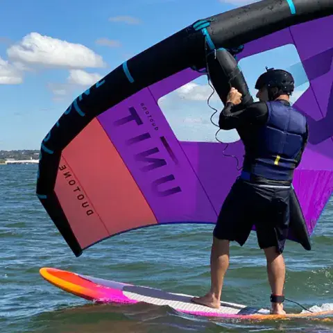 Pratiquant de wing foil avec son aile sur le lac