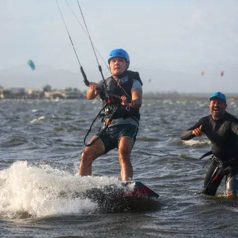 Deux kitesurfeurs dans l'eau peu profonde de la lagune
