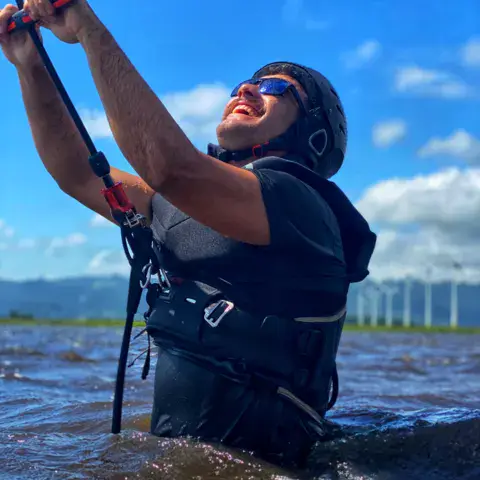Kitesurfeur avec casque et gilet, barre en main