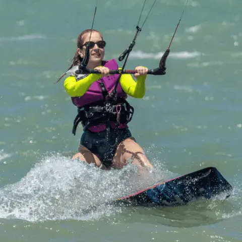 Kitesurfeuse sur l'eau avec harnais et gilet