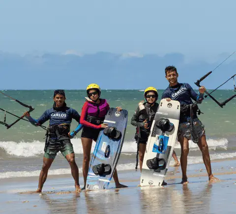 Groupe sur la plage avec planches de kitesurf