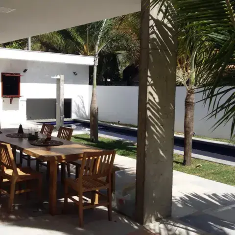Espace extérieur couvert avec table et palmiers