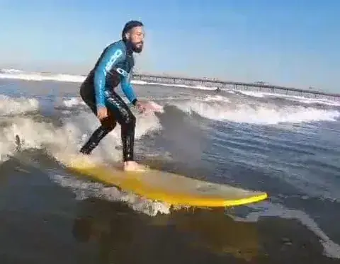Surfeur sur une planche jaune dans les vagues