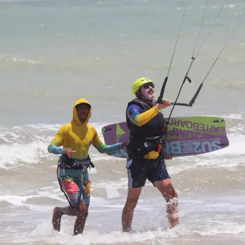 Deux kitesurfeurs sortant de l'eau avec une planche