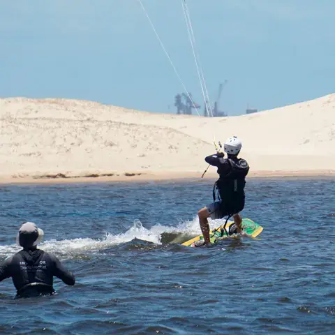 Kitesurfeur sur l'eau devant une dune