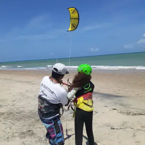 Explications sur la plage avec un kite jaune en vol